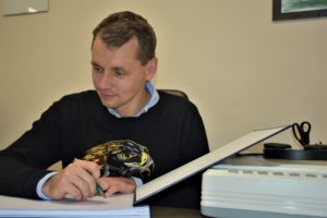 Łukasz Bożycki wpisujący się do kroniki biblioteki